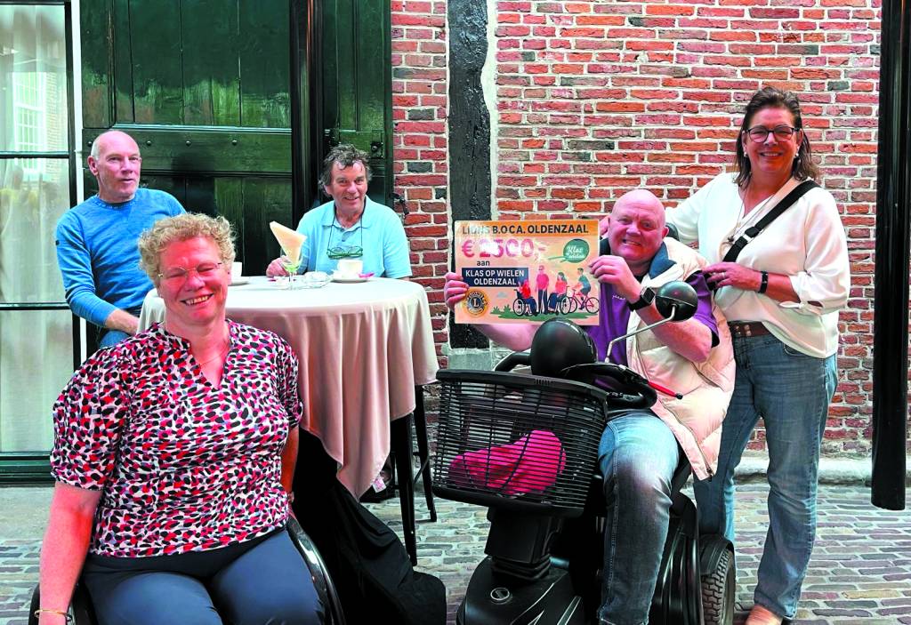 Namens Lions BOCA overhandigt Diane Smellink de cheque aan Hans Davina en Ellen Bos. Op de achtergrond Henk Winkelhuis en Bert Hellegers van het begeleidingsgroepje van Klas op Wielen.