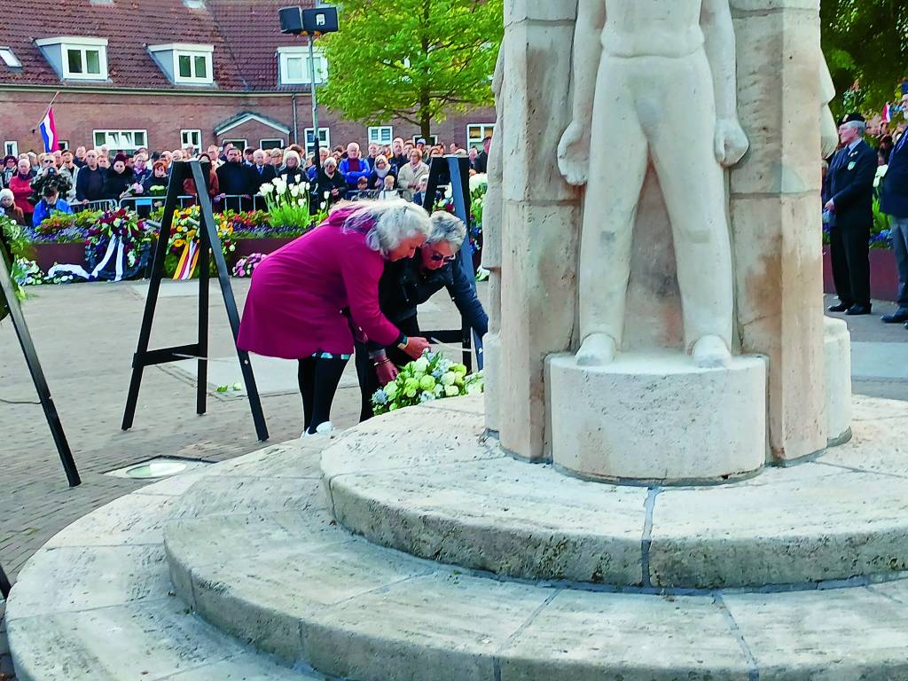 Mensen van de Joodse gemeenschap leggen een bloemstuk.